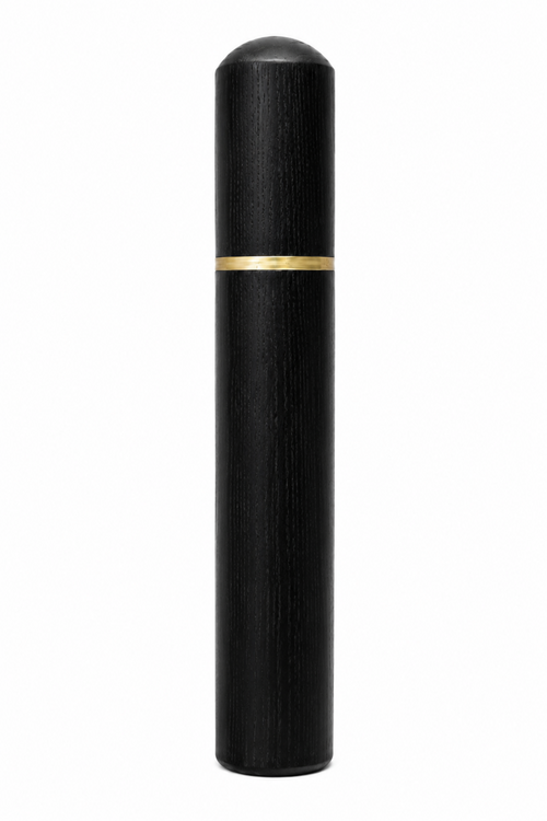 A sleek, black cylindrical cosmetic container with a textured wood grain finish, a rounded dome cap, and a thin horizontal gold band around the middle, isolated on a white background.