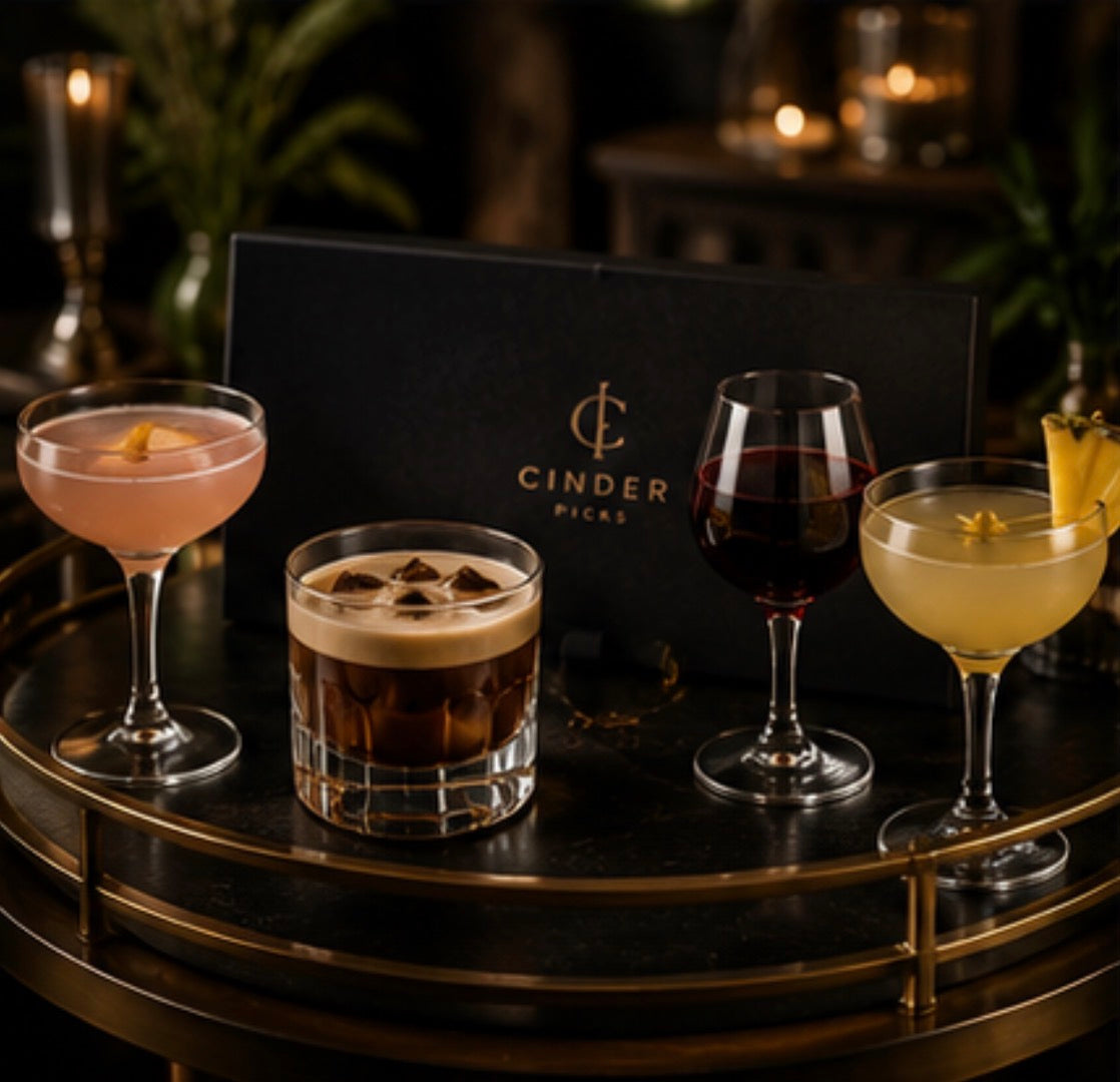 Four cocktails on a dark surface with 'Cinder Picks' branding in the background.