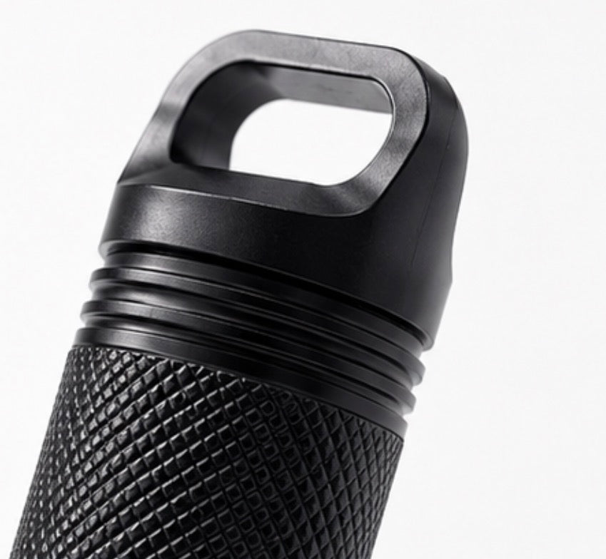 Close-up of a black textured cylindrical Cinder Picks flavoured toothpick holder with a loop handle on top, shown against a plain white background.