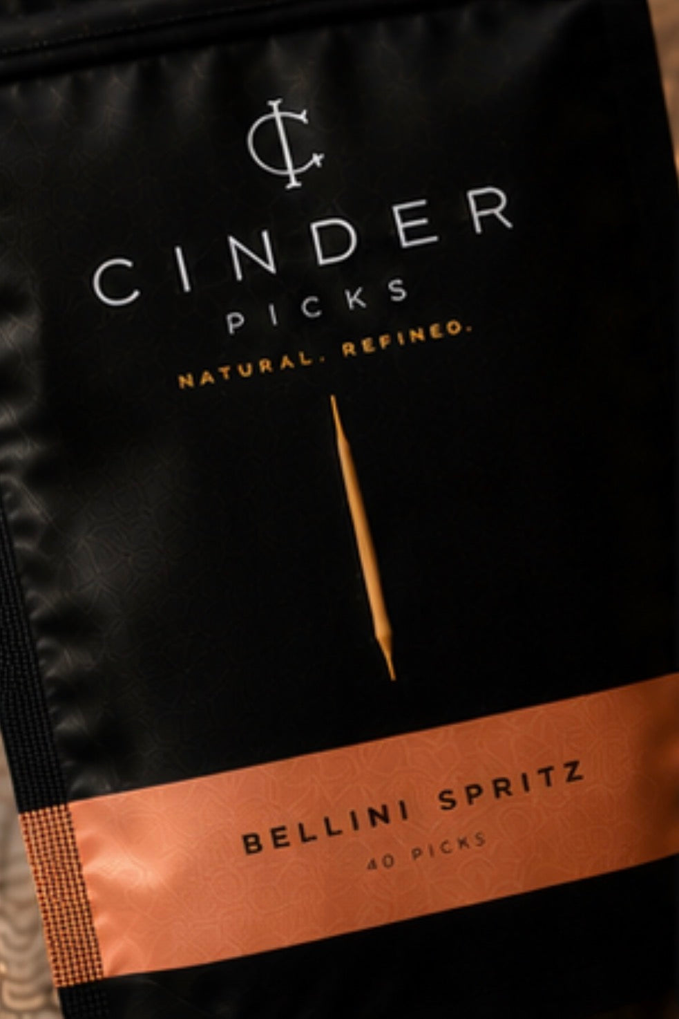 Cinder Picks packaging for Bellini Spritz flavour with a black and peach design.