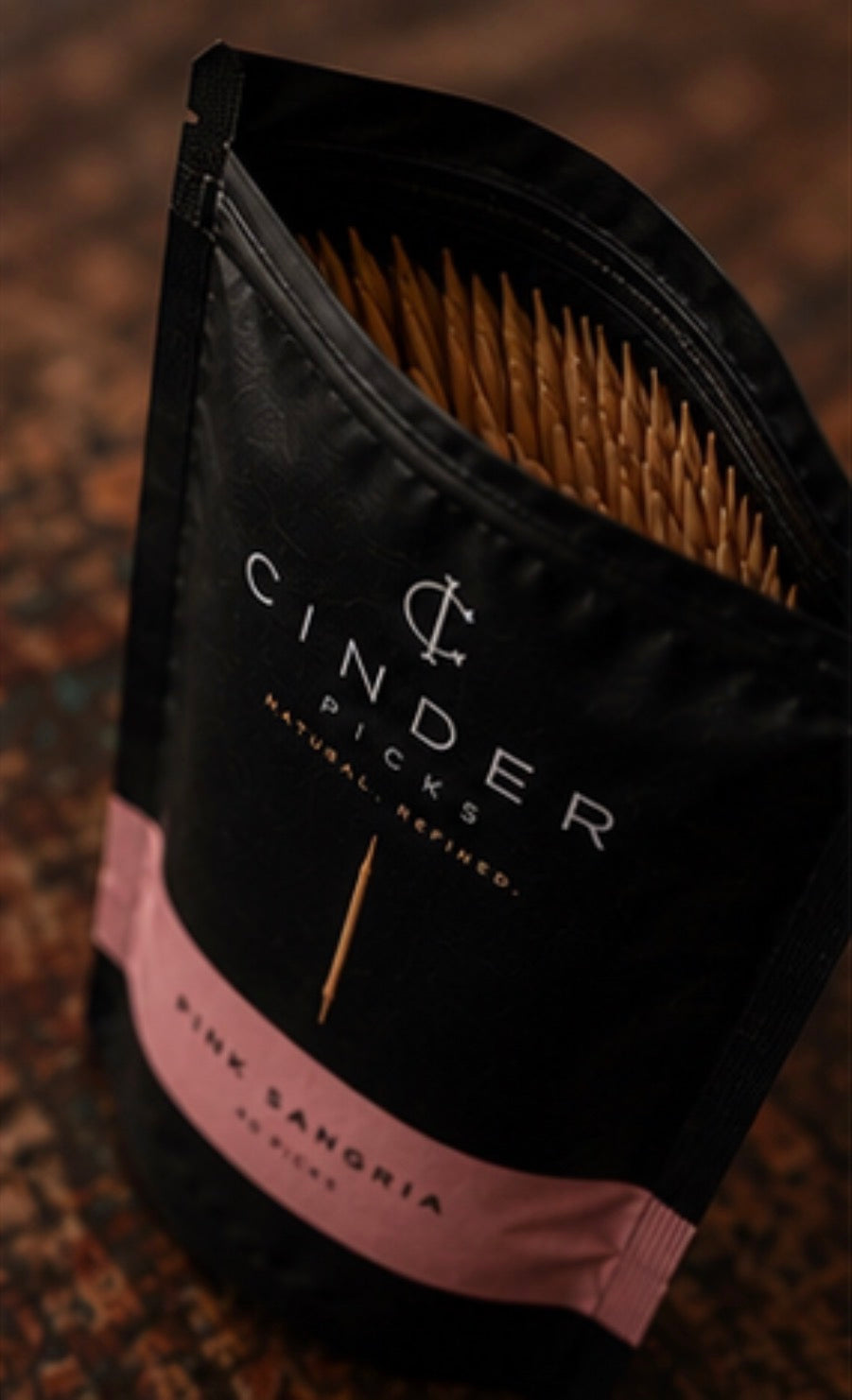 Packaged product with 'Cinder Picks' branding on a textured surface