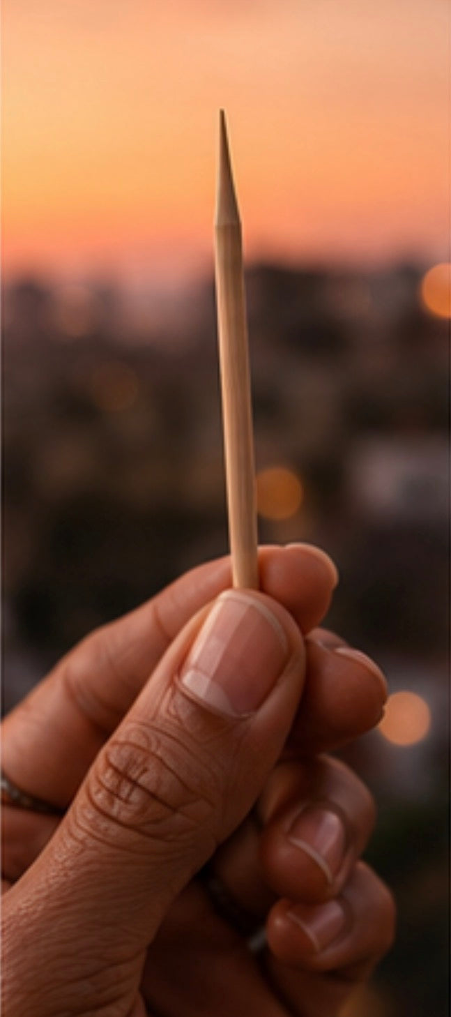 Hand holding a Cinder Pick with a blurred sunset background