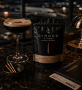 Espresso martini with a pouch of Cinder Picks on a dark surface