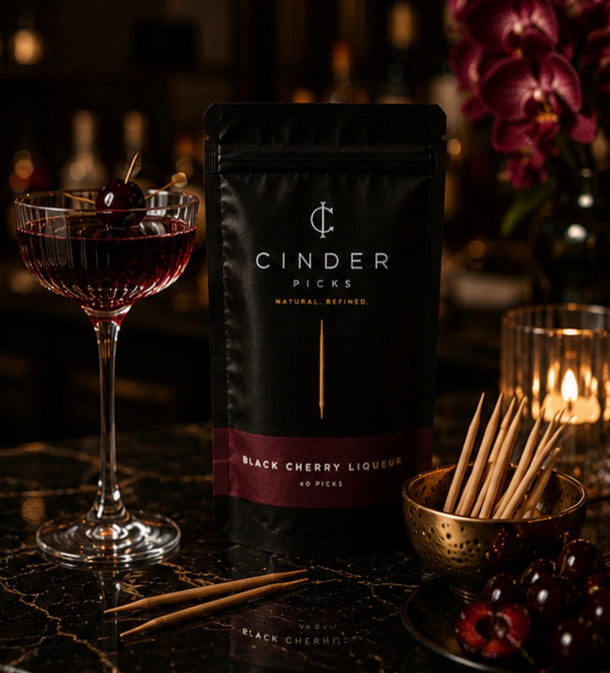 Cinder Picks black cherry liqueur pouch with a cocktail and cherry on a dark background