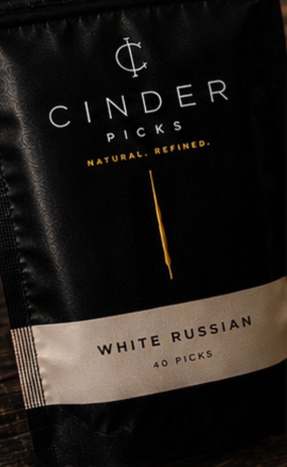 Cinder Picks packaging for White Russian flavor on a black background