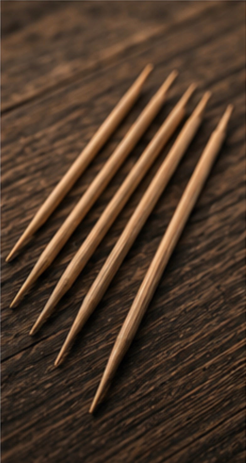 Five wooden toothpicks on a dark wooden surface