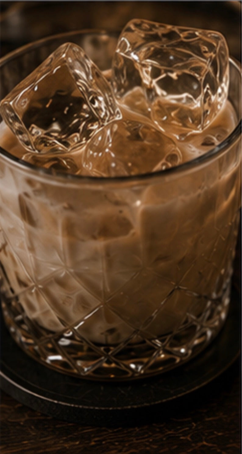 Glass of Irish Cream with ice cubes on a dark surface
