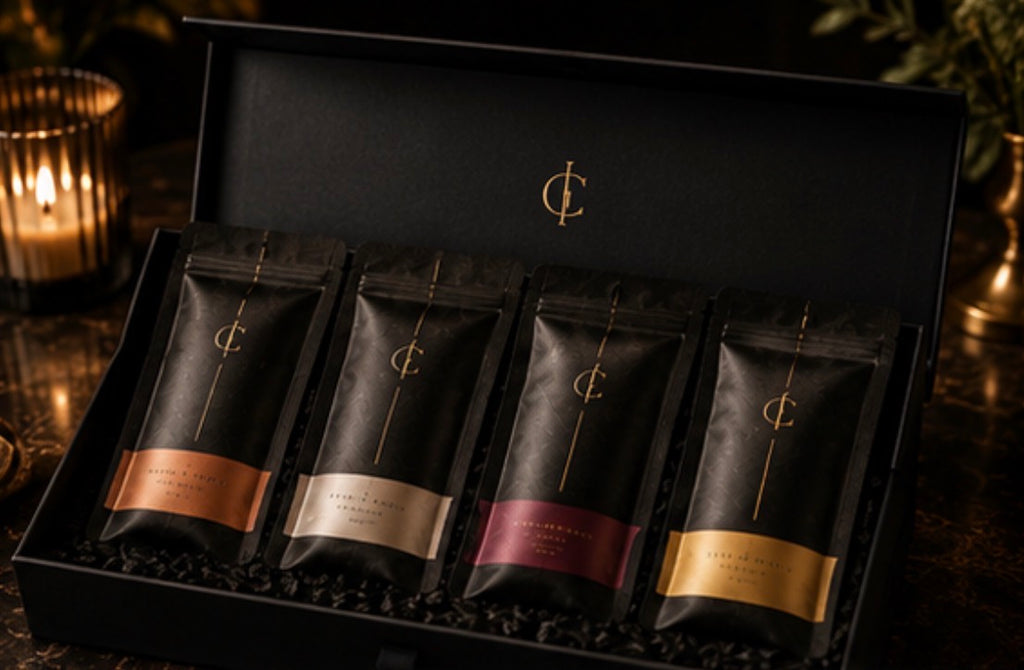 Set of four Cinder Pick pouches with a brand logo in a decorative box on a dark background.